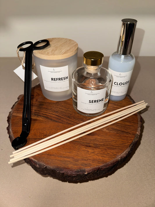Three diffuser bottles with labels on a wooden surface