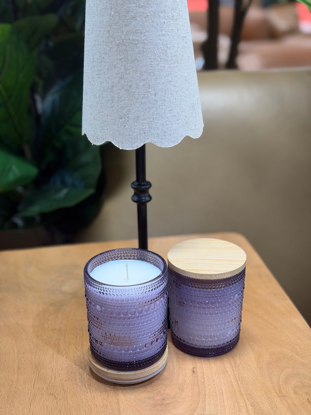 Two textured candles on a wooden surface with a blurred background