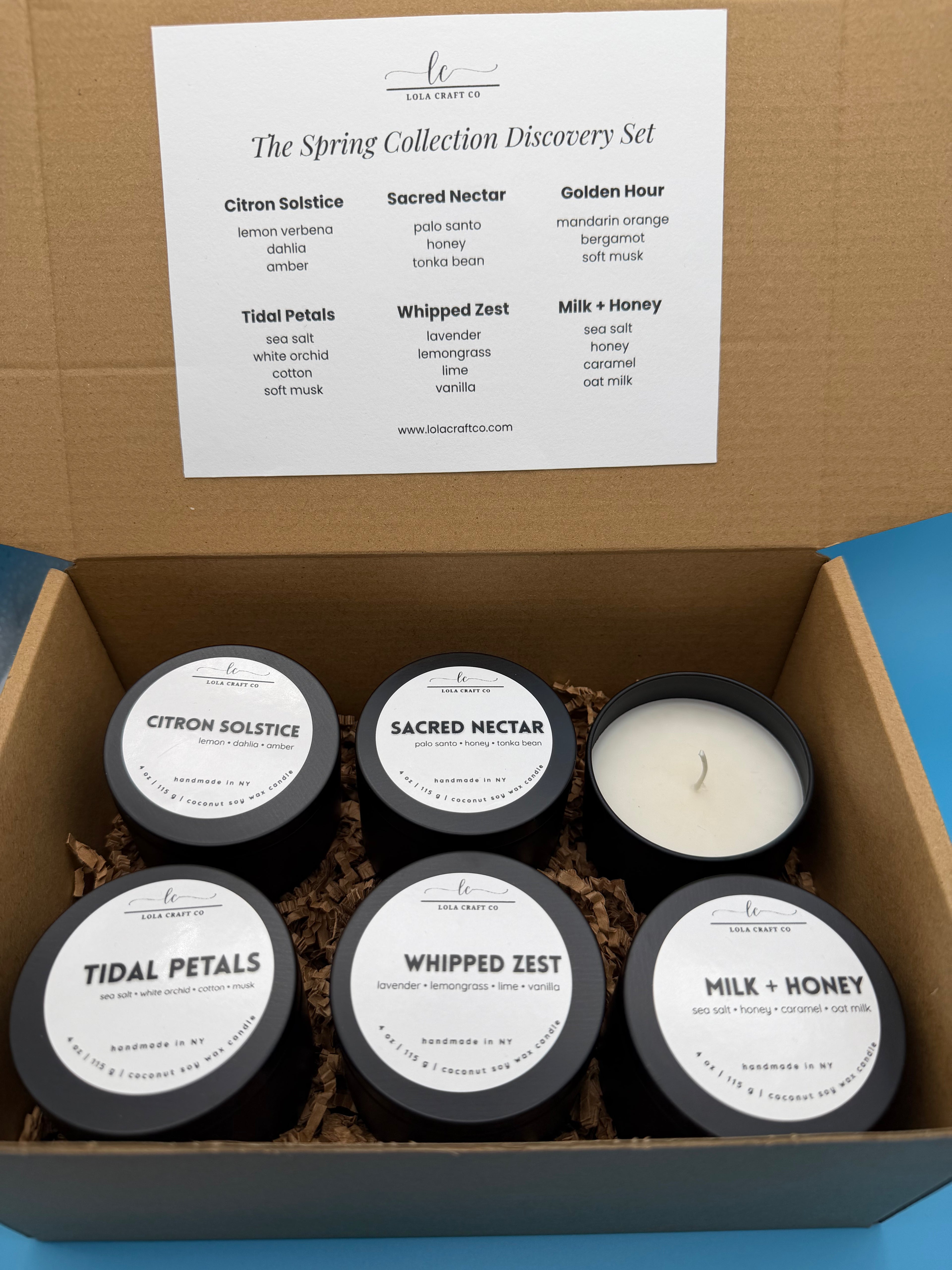 Set of candles in a box with labels and a card on a blue background